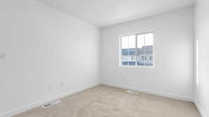 Spare room featuring light colored carpet