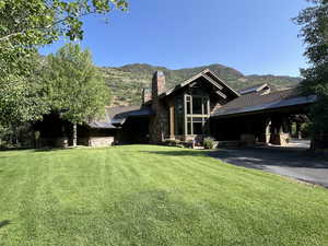 View of side of property featuring a mountain view and a yard