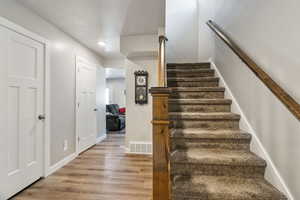 Stairway with wood-type flooring and a textured ceiling