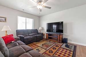 Living room featuring ceiling fan and hardwood / wood-style flooring