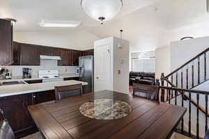 Dining area with vaulted ceiling and sink