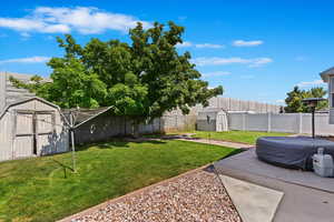 View of yard with a patio and a storage unit