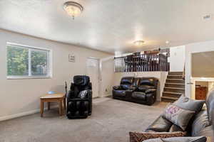 Living room with light colored carpet and a textured ceiling