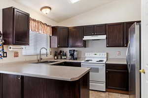 Kitchen with light tile patterned flooring, kitchen peninsula, white electric stove, stainless steel fridge, and sink