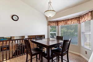 Dining room featuring vaulted ceiling and light tile patterned floors