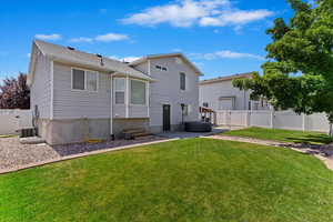 Rear view of house with a patio and a yard