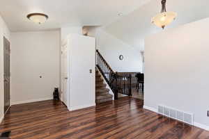 Foyer entrance featuring hardwood / wood-style flooring and lofted ceiling