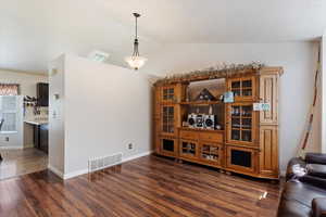 Living room with dark tile patterned floors and vaulted ceiling