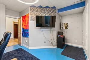 Interior space featuring a drop ceiling and a wall mounted air conditioner