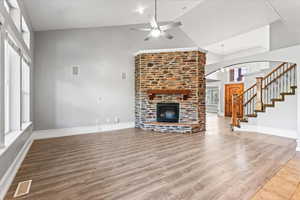 Unfurnished living room with high vaulted ceiling, a fireplace, ceiling fan, and hardwood / wood-style flooring