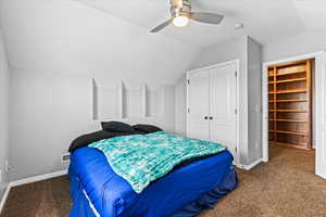 Carpeted bedroom with ceiling fan, lofted ceiling, and a closet