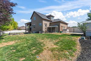 Rear view of house with a yard