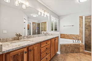 Bathroom with independent shower and bath, tile patterned floors, and dual bowl vanity