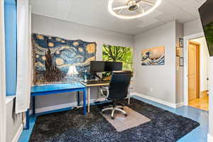 Office area featuring ceiling fan and concrete floors