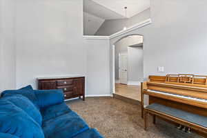 Living room with tile patterned floors and high vaulted ceiling