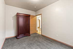 Unfurnished bedroom featuring carpet floors and a textured ceiling