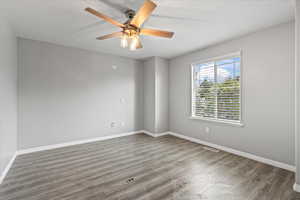 Empty room with ceiling fan and wood-type flooring