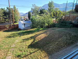 View of yard featuring a mountain view and a storage unit