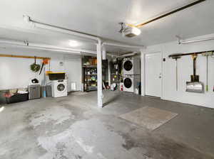 Garage featuring a garage door opener and stacked washer and dryer