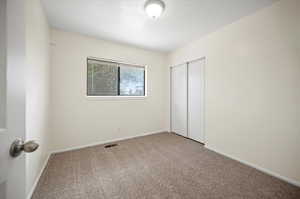 Unfurnished bedroom with a closet and carpet floors