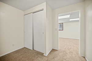 Unfurnished bedroom with a closet and light colored carpet