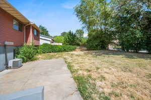 View of yard with central air condition unit and a patio area