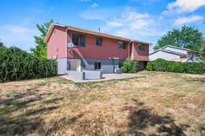 Back of property featuring a patio, cooling unit, and a yard