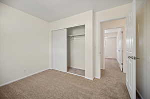 Unfurnished bedroom featuring carpet and a closet