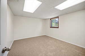 Carpeted empty room with a drop ceiling