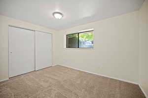 Unfurnished bedroom with a closet and carpet flooring