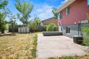 View of yard featuring central air condition unit, a patio, and a storage shed