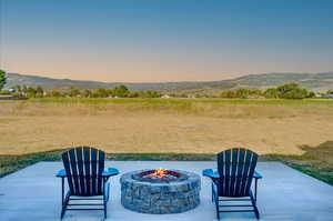 Patio terrace at dusk with a mountain view and an outdoor fire pit