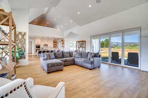 Living room featuring high vaulted ceiling and light wood-type flooring