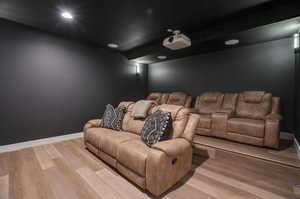 Home theater room with hardwood / wood-style flooring