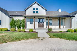 Modern inspired farmhouse with a porch and a front yard