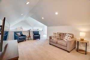 Living room featuring light carpet and vaulted ceiling