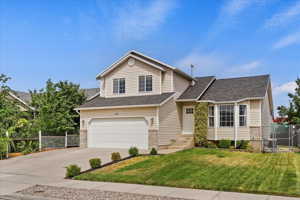 View of front of property featuring a garage and a front yard