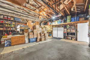 Garage with a garage door opener and white fridge