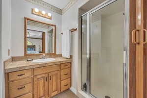 Master Bathroom featuring ceiling fan, vanity, and an enclosed shower