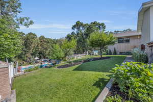 View of back yard behind trophy room, leads down to pool area