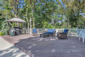 Pool area wooden terrace with grilling area, an outdoor living space, and a gazebo