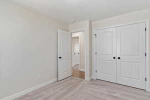 Unfurnished bedroom with light carpet and a closet