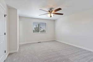 Carpeted empty room with ceiling fan