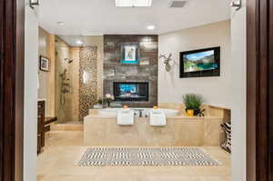 Bathroom with vanity, separate shower and tub, a fireplace, and tile patterned flooring