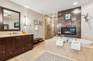 Bathroom with plus walk in shower, vanity, tile patterned floors, and a fireplace