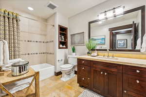 Full bathroom featuring vanity, toilet, tiled shower / bath, and tile patterned flooring