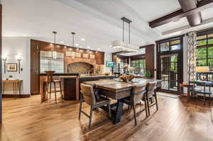 Dining space featuring a chandelier, coffered ceiling, hardwood / wood-style floors, and sink