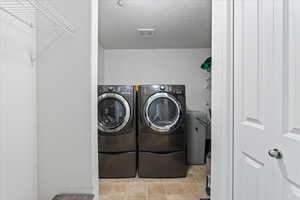 Laundry room featuring light tile patterned flooring and washer and dryer