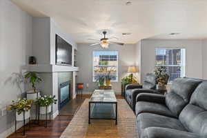 Living room featuring dark wood-type flooring and ceiling fan