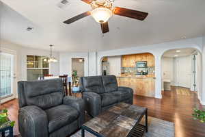 Living room featuring sink, dark hardwood / wood-style flooring, and ceiling fan with notable chandelier